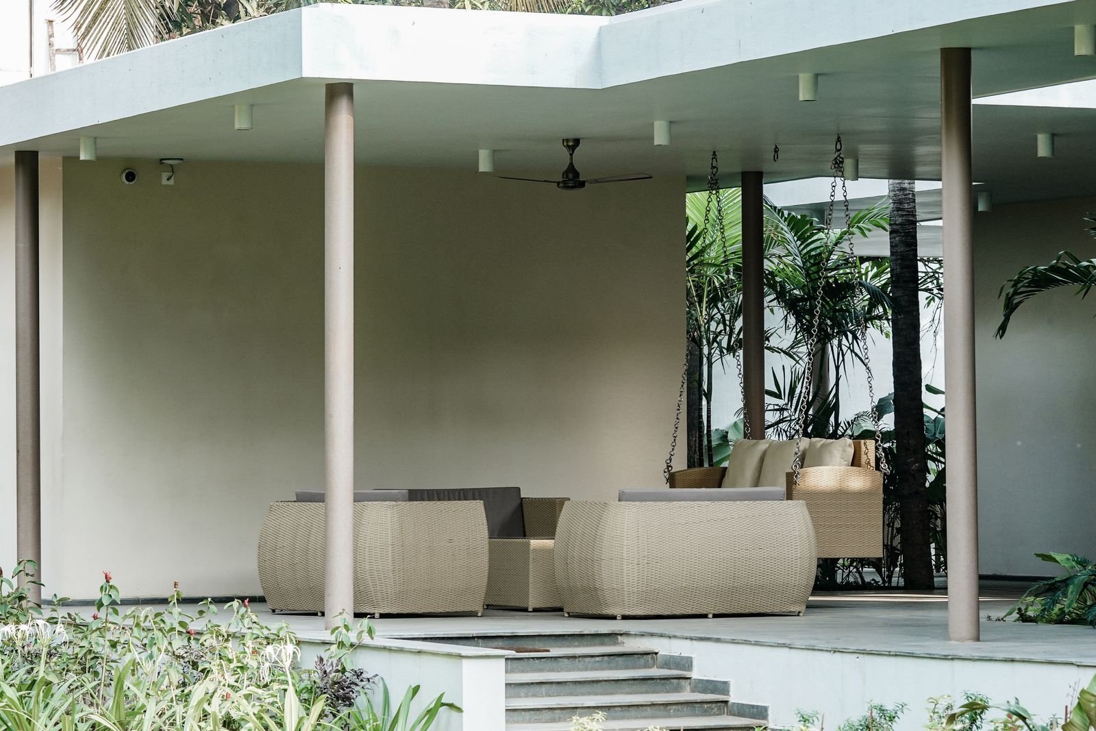 Covered outdoor room with white columns and lounge seating
