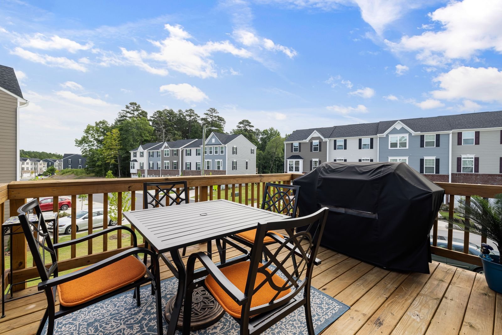 Raised timber deck with railing, outdoor furniture and a grill