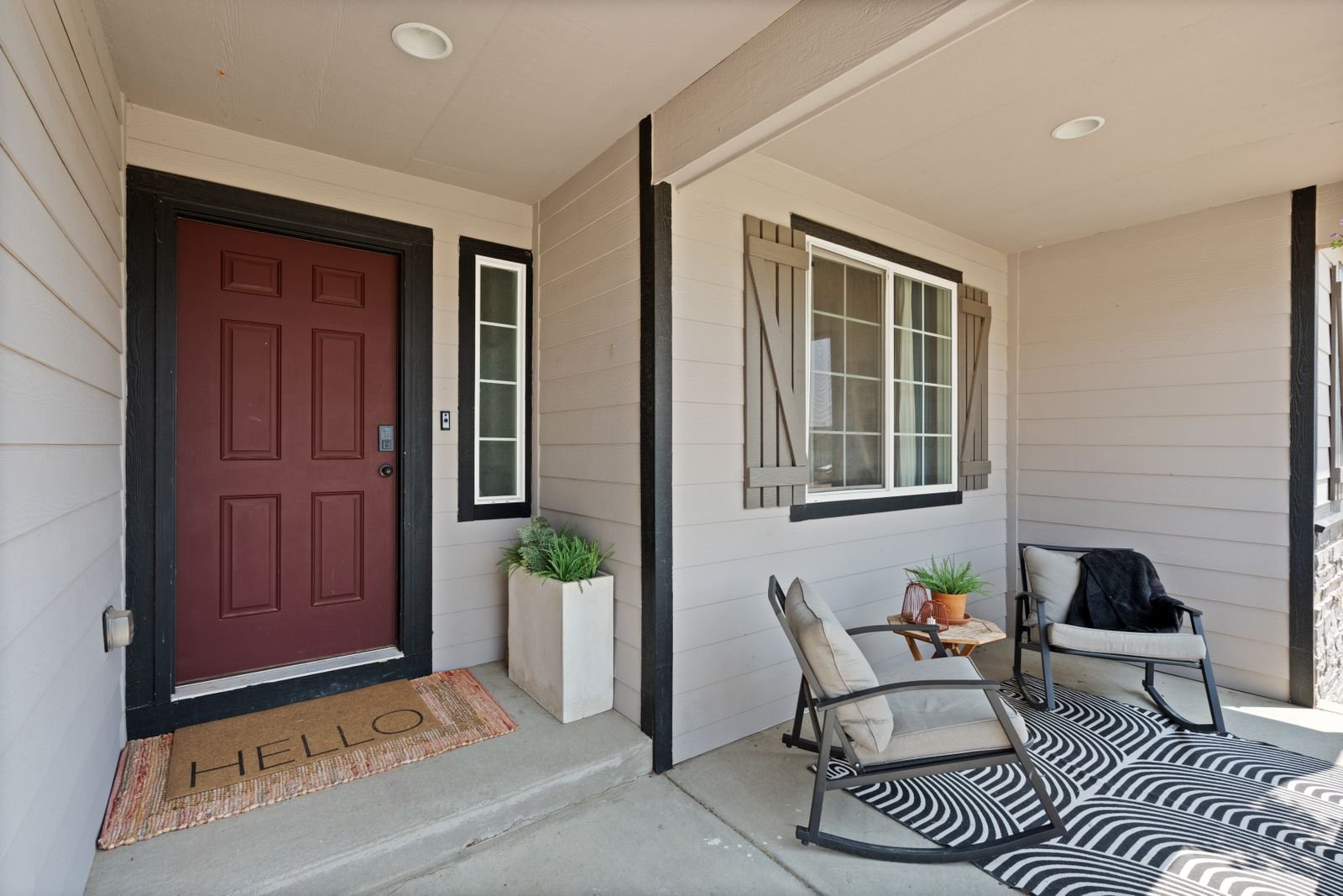 Small covered seating area beside a house entrance