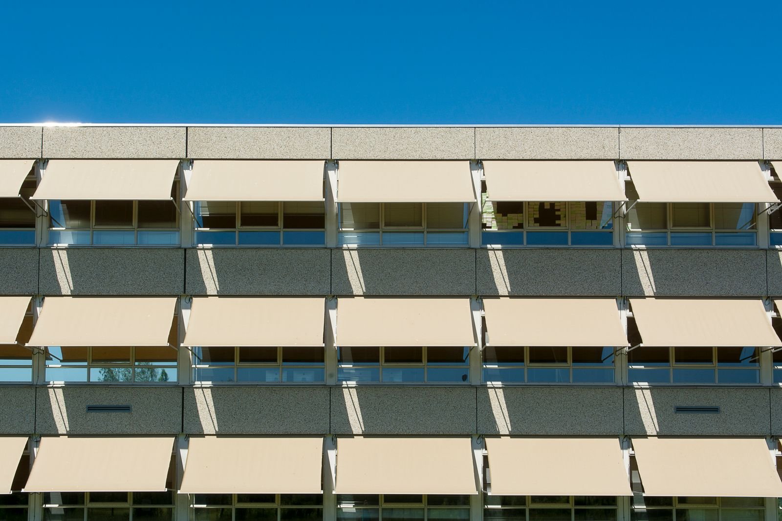 External sun shades fitted over glazing on a building facade